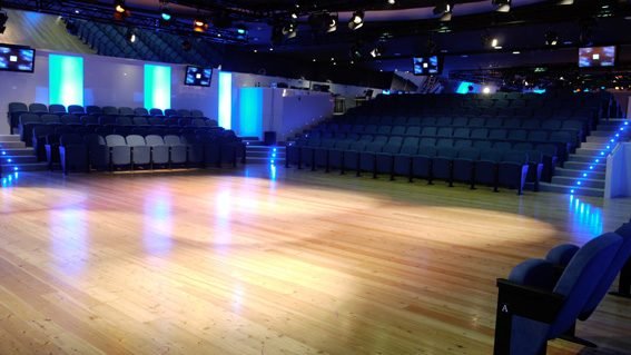Auditorium of Teatro Golden in Rome seen from the stage, with the blue seats and the parquet