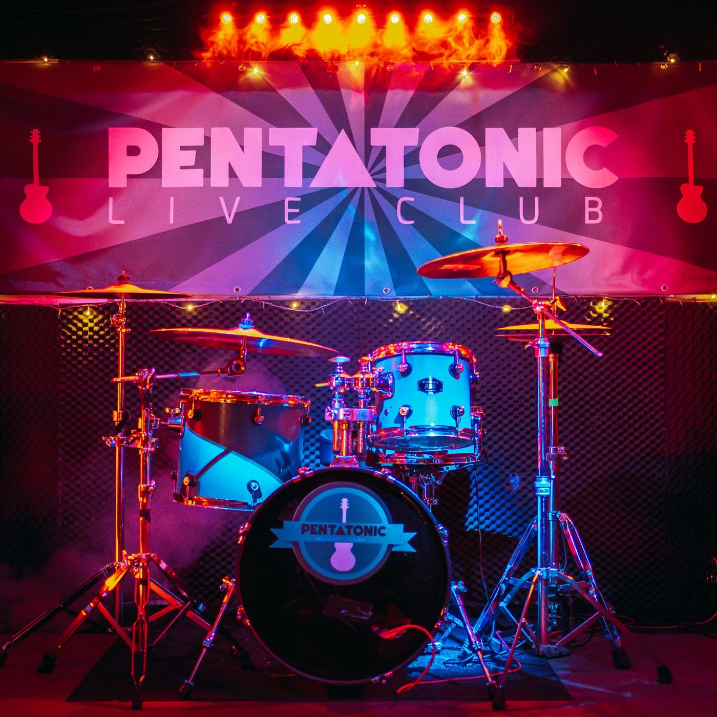 Stage of the Pentatonic Live Club with drum kit and a backdrop lit in red