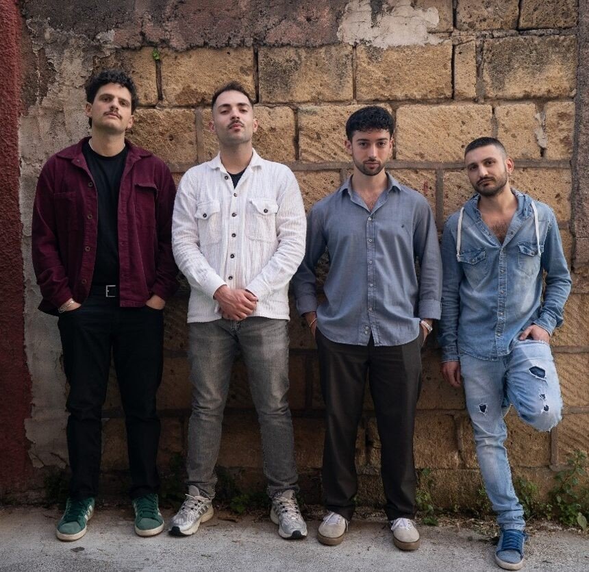 Foto del Nexus Quartet: quattro giovani musicisti in piedi davanti a un muro di blocchi di tufo