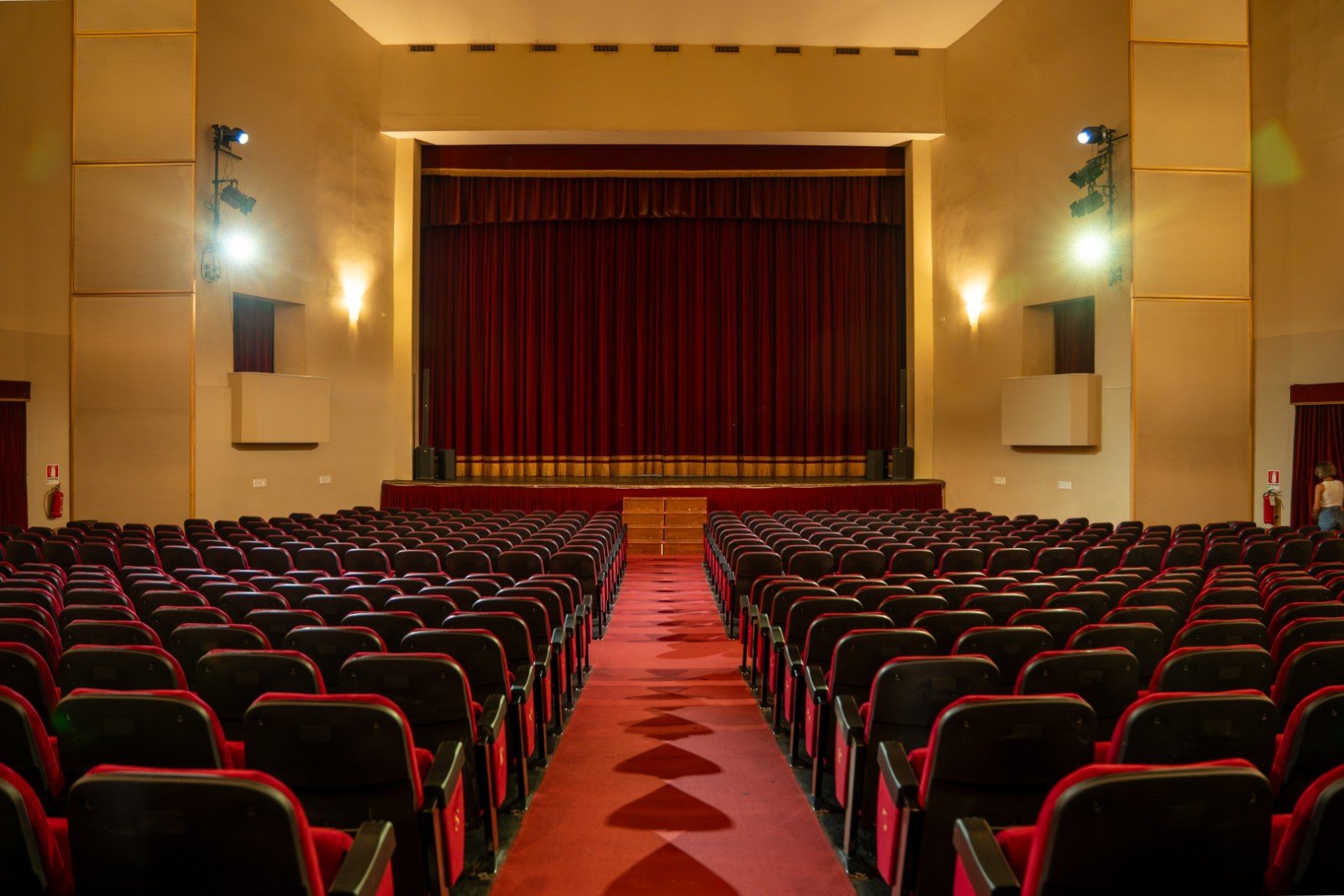 La sala del Teatro Italia di Via Bari a Roma, con platea di poltrone rosse e sipario chiuso